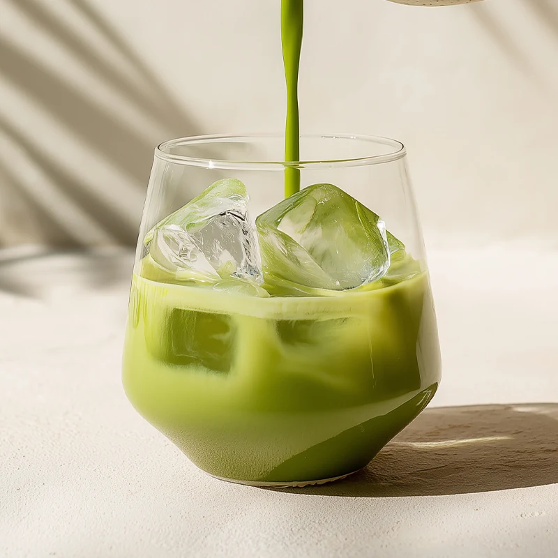 Grön matcha hälls i ett glas med mjölk och is.